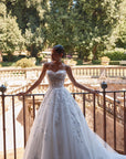 Brautkleid Veni Infantino präsentiert eine Braut im Atelier mit schöner Landschaft im Hintergrund.