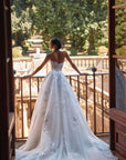 Brautkleid Veni Infantino präsentiert eine Braut im Atelier mit schöner Landschaft im Hintergrund.