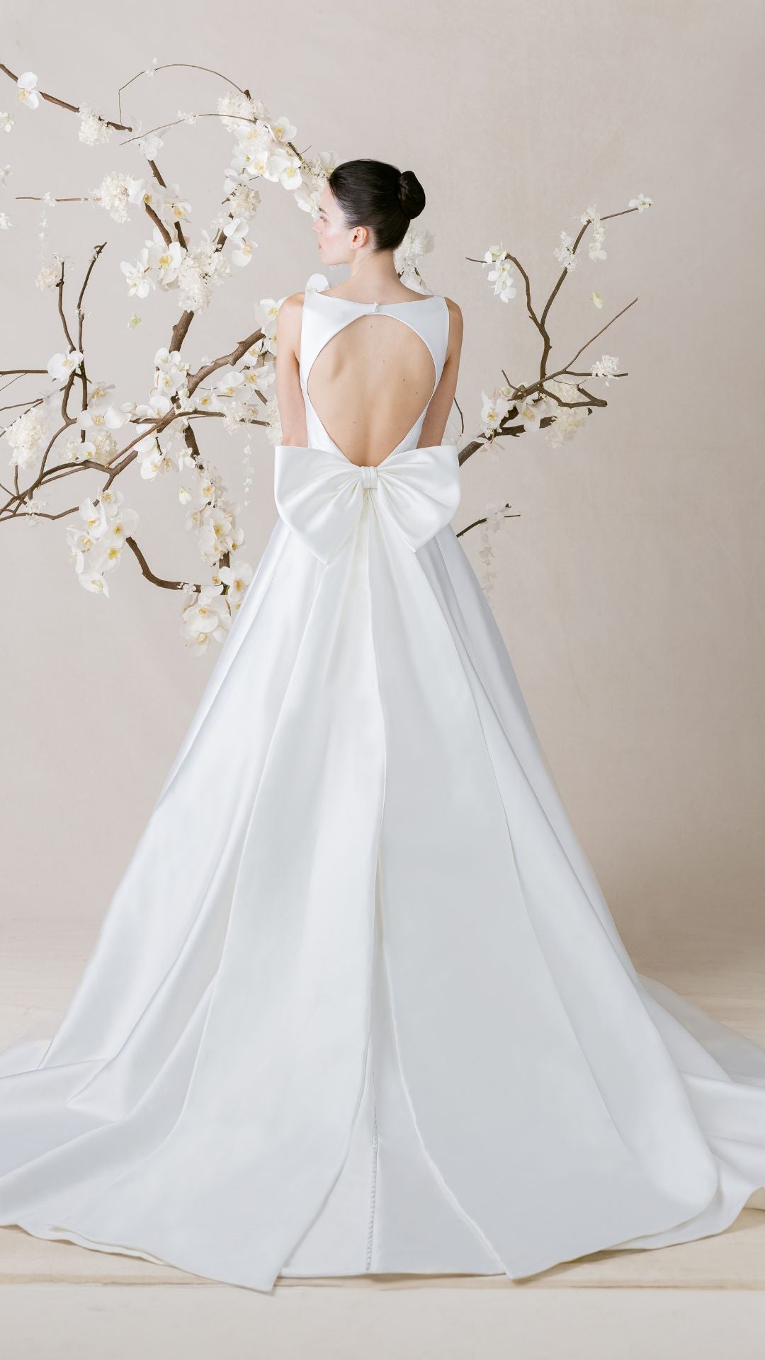 Elegantes Brautkleid von Morilee, präsentiert mit zarten Blumen im Hintergrund, perfekte Wahl für den großen Tag.