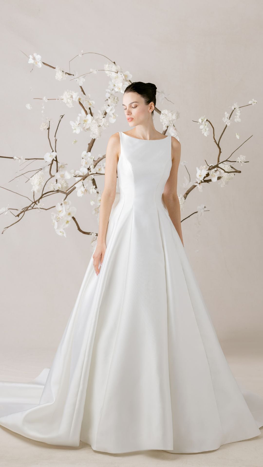 Elegantes Brautkleid von Morilee, präsentiert mit zarten Blumen im Hintergrund, perfekte Wahl für den großen Tag.