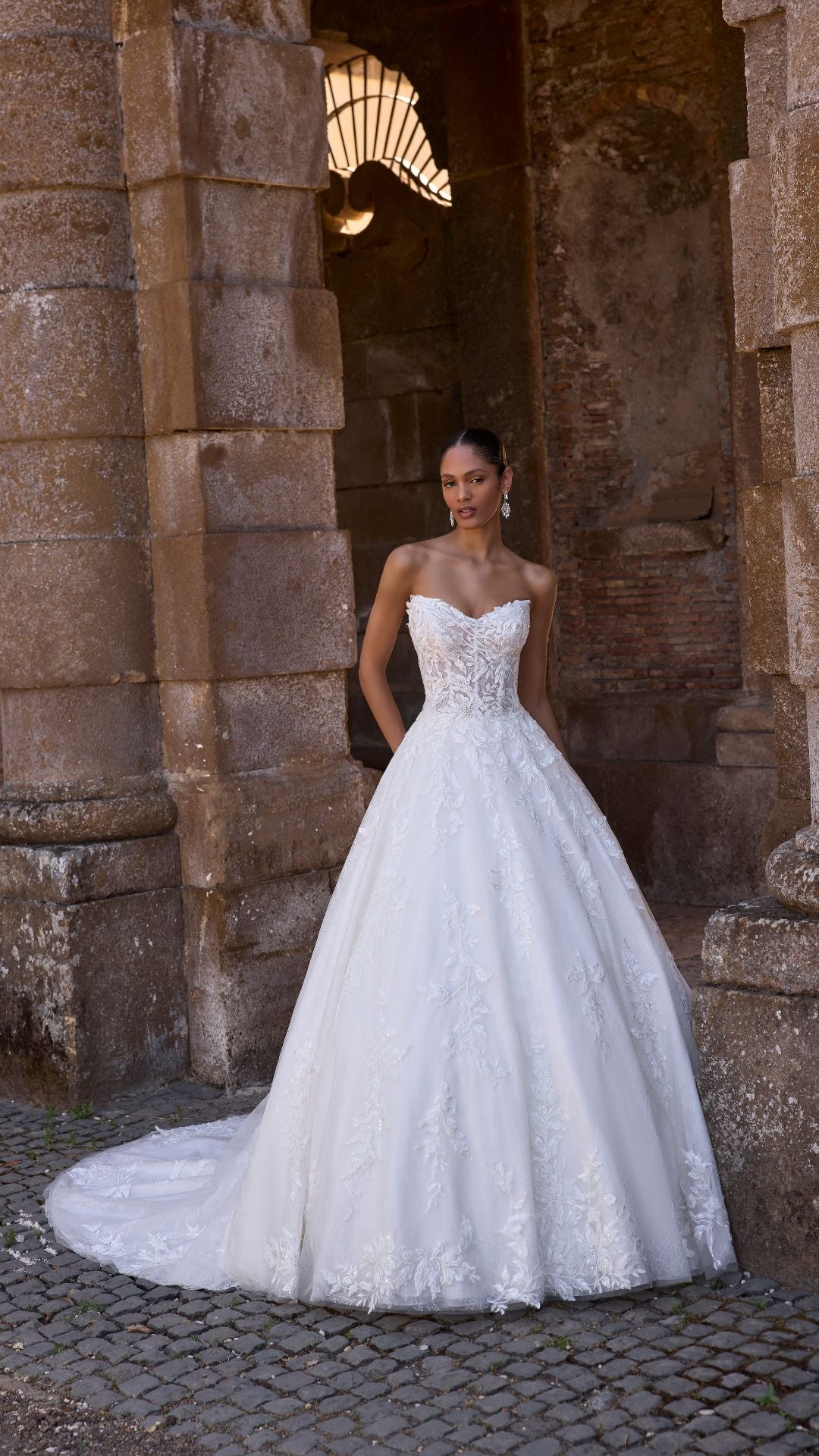 Elegantes Brautkleid von Veni Infantino mit schmalem Oberteil und voluminösem Rock, perfekt für besondere Anlässe.